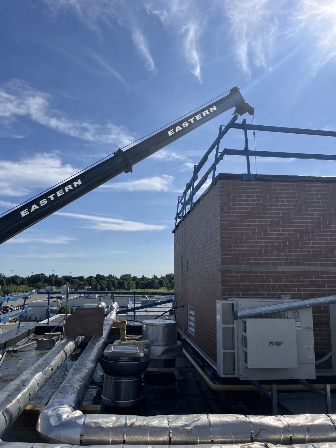 Eastern Crane Rentals boom positioned over a commercial rooftop RTU project